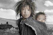 Джигме, 8 лет и Сонам, 18 месяцев. Ладак. «Джигме и Сонам — сестры из семьи кочевников, которая только что спустилась с Гималаев в свой зимний лагерь, расположенный на Тибетском плато на высоте 5000 м над уровнем моря. Когда я показал Джигме ее портрет на поляроидном снимке, она вскрикнула и убежала в шатер. Я понял, что она впервые видела себя со стороны, потому что в ее семье нет зеркала.