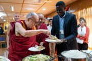 Его Святейшество Далай-лама кладет еду Виктору Очену из Уганды во время обеда, организованного в первый день диалога с юными миротворцами. Дхарамсала, Индия. 23 октября 2019 г. Фото: Тензин Чойджор (офис ЕСДЛ).