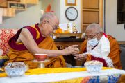 Его Святейшество Далай-лама предлагает Тикси Ринпоче ритуальный сладкий рис во время церемонии освящения библиотеки в монастыре Тикси, в Ле, Ладак, Индия, 25 июля 2022 года. Фото: Тензин Чойджор