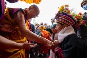 Поднимаясь на сцену в начале второго дня учений, Его Святейшество Далай-лама приветствует ладакского мальчика. Ле, Ладак, Индия. 29 июля 2022 года. Фото: Тензин Чойджор (офис ЕСДЛ).