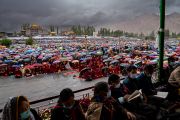 Собравшиеся укрываются под зонтами во время начавшегося дождя во второй день учений Его Святейшества Далай-ламы на учебной площадке Шевацель. Ле, Ладак, Индия. 29 июля 2022 года. Фото: Тензин Чойджор (офис ЕСДЛ).