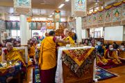 Монах держит микрофон, в то время как Его Святейшество Далай-лама обращается к собравшимся в ходе заключительного дня ежегодной пятидневной церемонии подношения Гуру Падмасамбхаве. Дхарамсала, штат Химачал-Прадеш, Индия. 9 октября 2022 г. Фото: Тензин Чойджор (офис ЕСДЛ).